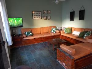 a living room with a couch and a tv at Casa da Prainha in Arraial do Cabo