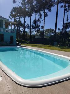 a large blue swimming pool in a yard at Recanto do sossego in São Bento do Sapucaí +12 photos