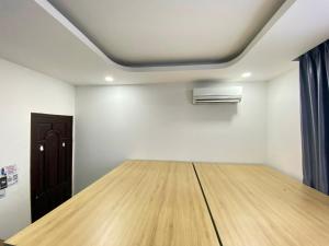 Cette chambre dispose d'une table en bois et d'un plafond. dans l'établissement Start House CAPSULE 5 min walk to the Airport, à Hô-Chi-Minh-Ville