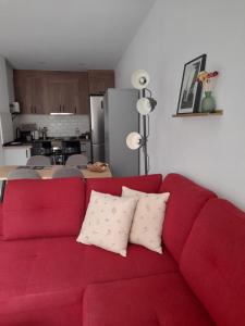 a red couch with two pillows on it in a kitchen at Apartamento El Lago Cartagena Centro. in Cartagena