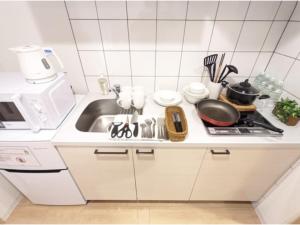 a white kitchen with a sink and a stove at Eslead Hotel Osaka Tsuruhashi - Vacation STAY 77488v in Osaka