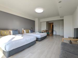 a hotel room with two beds and a couch at Eslead Hotel Osaka Tsuruhashi - Vacation STAY 77737v in Osaka
