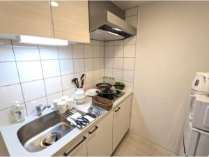 a small kitchen with a sink and a stove at Eslead Hotel Osaka Tsuruhashi - Vacation STAY 77560v in Osaka +3 photos