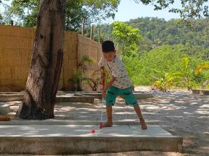 a young boy playing with a ball on a sidewalk at BeachWalk Koh Rong in Koh Rong Island