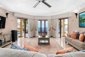a living room with a couch and a tv at Oceanfront Luxe Villa In St Mary Fully Staffed in St Mary