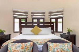 a bedroom with a large bed with two chairs at Oceanfront Luxe Villa In St Mary Fully Staffed in St Mary