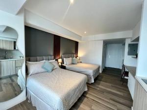 una camera d'albergo con due letti e una cucina di Jemet - Moderno Apartamento Doble a Guatemala