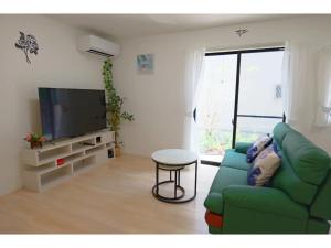 un salon avec un canapé vert et une télévision dans l'établissement Ciao No,361 - Vacation STAY 61635v, à Tsukuba