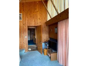 sala de estar con paneles de madera y TV en HANAMIDORI Soshino Sanso - Vacation STAY 16181 en Gujo