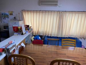 uma cozinha com mesa e cadeiras e uma cozinha com frigorífico em HANAMIDORI Oppara no Yado - Vacation STAY 16099 em Gujo