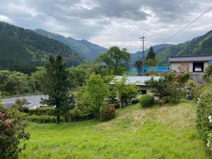 una casa su una collina con una strada e montagne di HANAMIDORI Soshino Sanso - Vacation STAY 16181 a Gujo