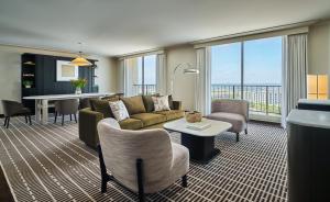 sala de estar con sofá, sillas y mesa en Pendry Newport Beach, en Newport Beach