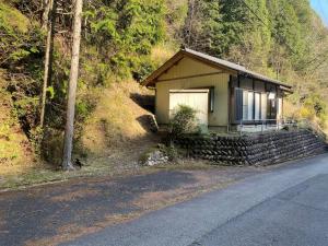 een klein huis aan de kant van een berg bij HANAMIDORI Sugata Hotaru no Sato - Vacation STAY 16201 in Gujo