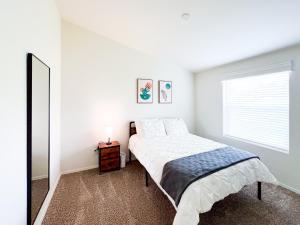 een witte slaapkamer met een bed en een spiegel bij Ridgeview Oasis in Poway