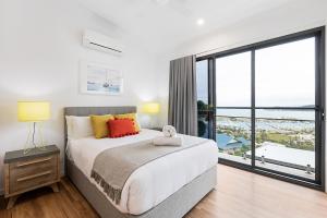 ein Schlafzimmer mit einem Bett und einem großen Fenster in der Unterkunft Elementa Whitsundays in Airlie Beach + 37 Fotos