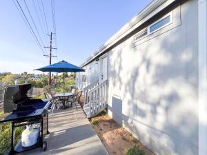 a patio with a table and an umbrella and a table and a television at Ridgeview Oasis in Poway