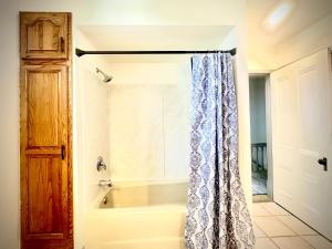 a bath tub with a shower curtain in a bathroom at The Second Story in Raton