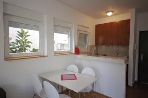 eine Küche mit einem weißen Tisch und weißen Stühlen in der Unterkunft Studio Apartment Danijela in Igalo