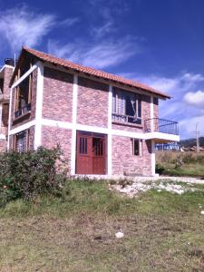 Cette maison en briques possède un balcon sur le côté. dans l'établissement Casa De Los Colores, à Paipa