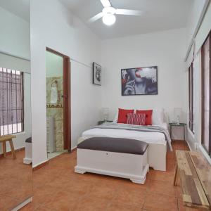 een witte slaapkamer met een bed en een plafondventilator bij Apartamento de un solo piso zona colonial in Santo Domingo
