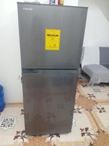 a refrigerator with a yellow sticker on it in a room at Noana Crib in Davao City
