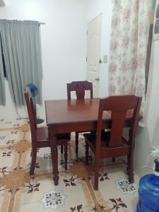 a dining room with a wooden table and chairs at Noana Crib in Davao City