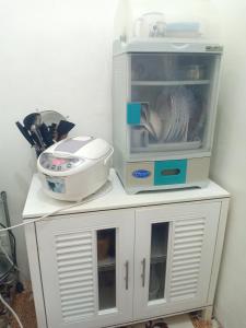a white cabinet with a kitchen appliance on top of it at Noana Crib in Davao City