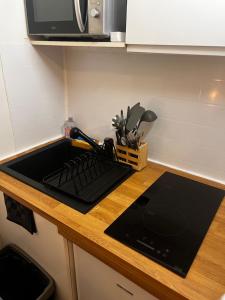 a kitchen counter with a sink and a microwave at Lilliputiens in Rouen +13 photos