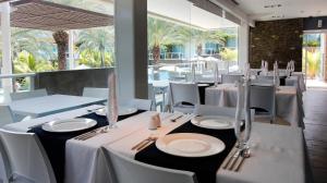 une salle à manger avec des tables et des chaises blanches dans l'établissement Hotel Boutique Maloka, à Flandes
