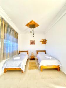 1 dormitorio con 2 camas y ventana en oualidia surfhouse, en Oualidia