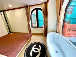 ein Badezimmer mit einer Badewanne, einem Bett und einem Bett sowie einer Badewanne in der Unterkunft L’abri Retreat _ Venuestay in Tam Ðảo