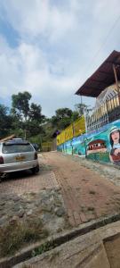 ein Auto, das auf einer Backsteinstraße neben einer Mauer geparkt ist in der Unterkunft Finca los tucanes in Villamaría