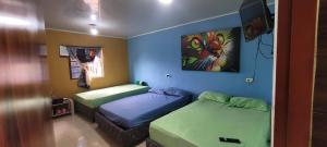 Habitación con 2 camas y una pintura en la pared. en Finca los tucanes, en Villamaría