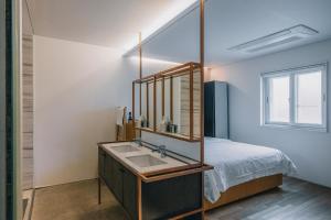 a bathroom with a sink and a bed at Gwangju Hotel the spot in Gwangju