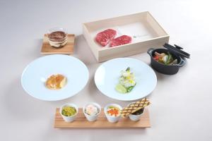 una mesa con tres platos y una caja de comida en Snow Peak YAKEI SUITE ABURAYAMA FUKUOKA en Fukuoka