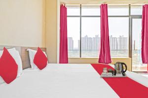 a bedroom with a large bed with red pillows at OYO Star Residency Near Omaxe Gurgaon Mall in Gurgaon