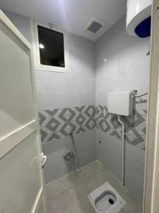 a bathroom with a toilet and a window at شقق خاصة مع حوش مدخل خاص in Sidīs