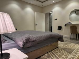 una camera con letto e tavolo con lampada di Apartment on city a Riyad