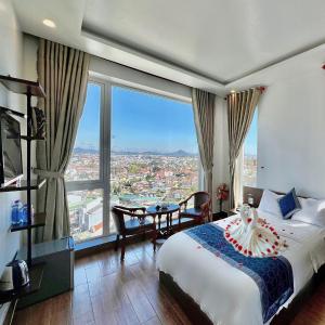una camera d'albergo con letto e tavolo con vista di Cosy Hotel & Apartment Dalat a Da Lat