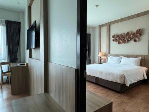 a hotel room with a bed and a television at Civilize Hotel in Udon Thani