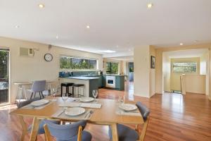 une salle à manger avec une table et des chaises ainsi qu'une cuisine dans l'établissement Relax on Queens - Waikanae Beach Holiday Home, à Waikanae