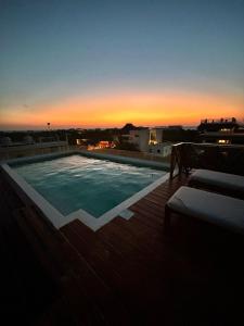 uma piscina no telhado de um edifício com o pôr do sol em sunsteps dragonfly room em Ilha Holbox