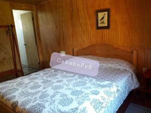 Una cama con un cartel en un dormitorio en Acogedora cabaña para disfrutar y descansar, en Olmué