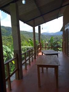 a porch with benches and a view of the mountains at RS Holiday Residence in Ilukkumbura