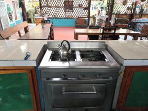 a kitchen with a stove with a tea kettle on it at Alojamiento Sumak Kawsay in Puerto Ayora
