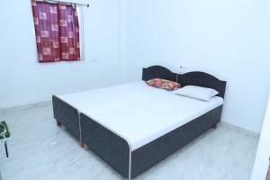 un letto in una camera con struttura nera di OYO Shiv guru guest house a Bodh Gaya