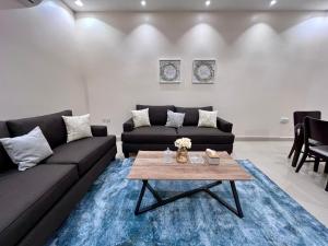 a living room with a couch and a table at شقق نسج المسكن دخول ذاتي شمال الرياض in Riyadh +62 photos