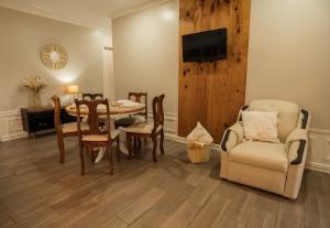 a dining room with a table and chairs and a television at Victoria´s House in Grecia