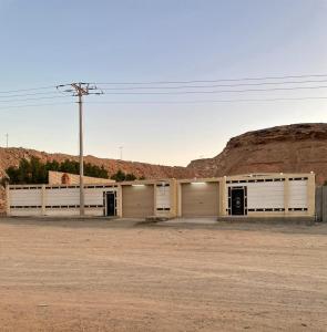 ein Gebäude mit drei Garagentüren in der Wüste in der Unterkunft شاليه الفخامه٢ in Ḑubā