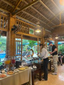 2 personnes debout dans un restaurant préparant des repas dans l'établissement Trang An Mountain House, à Ninh Binh